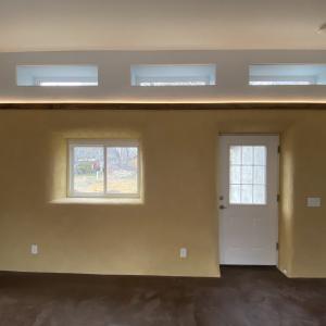 North living room wall w/ clerestory windows and arch. lighting