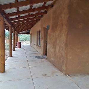 Wraparound porch and clay plaster wall.